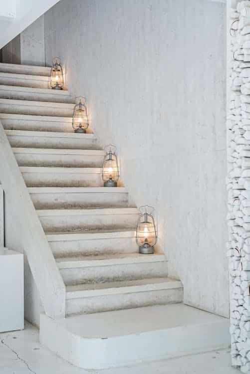 Photo d'un escalier blanc avec des lanternes illustrant les marches pour aller consulter ses annales akashiques